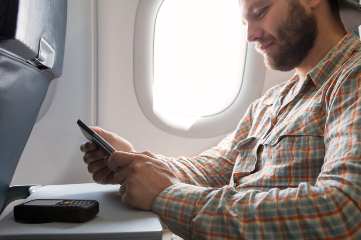 ragazzo con smartphone in aereo