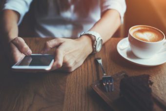 mani che usano smartphone in un bar - cappuccino